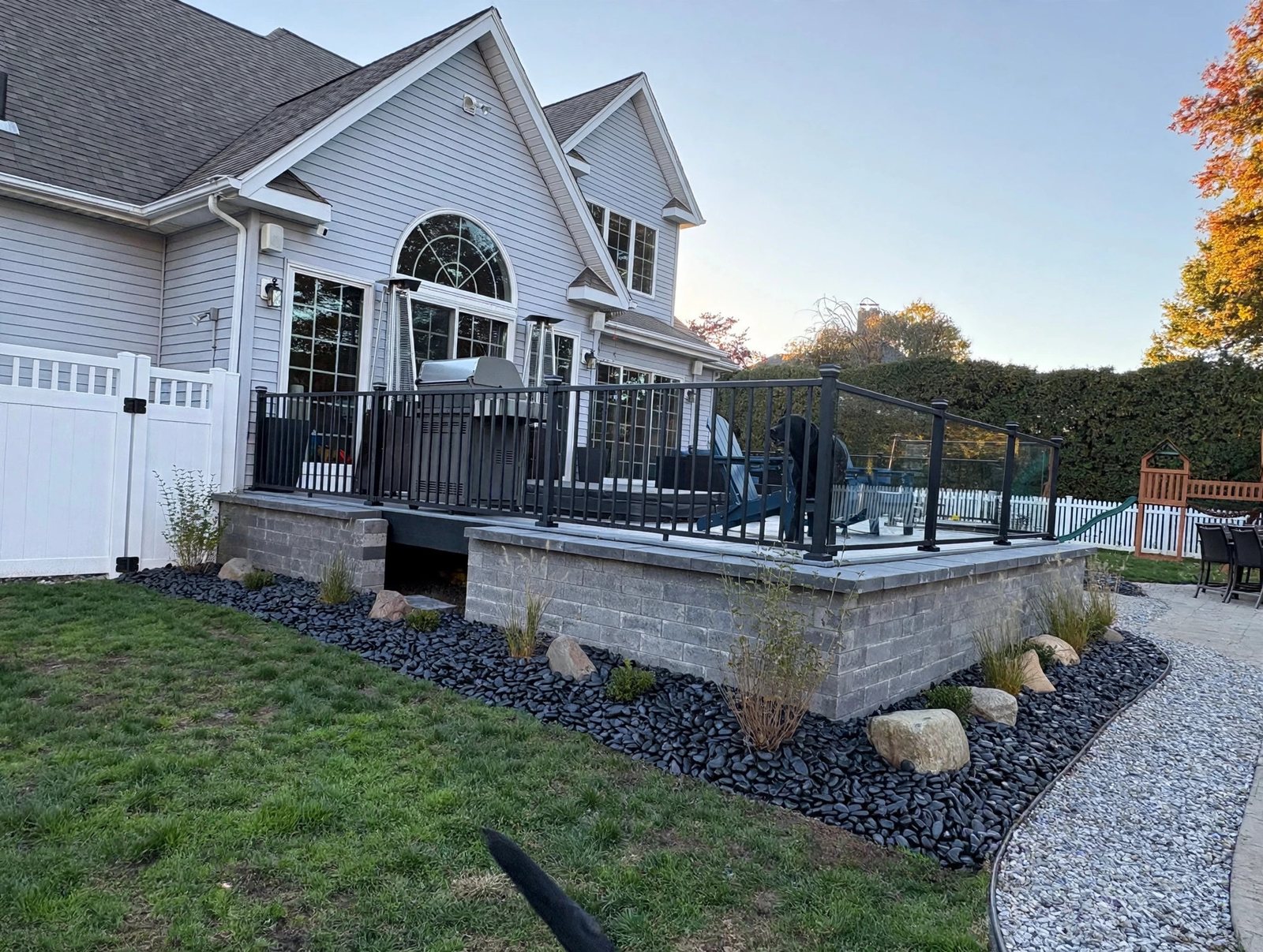 Real stone skirting and black aluminum railing on a custom deck in Suffield, Connecticut